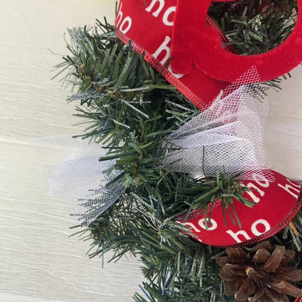 Believe evergreen faux wreath trimmed with the word believe and ho ho ho ribbon